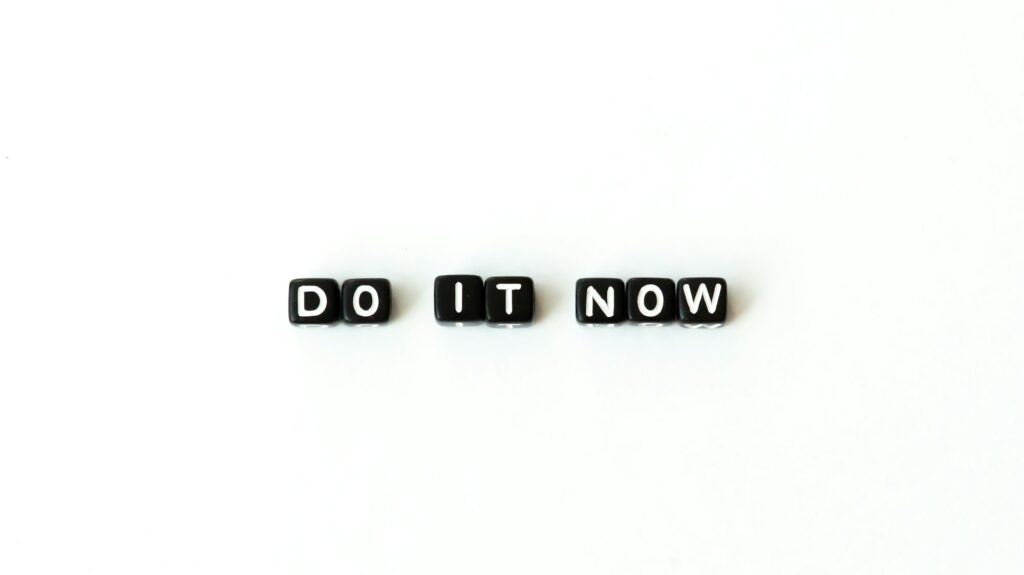 Do it now motivation quote in black letter beads on white background. Top view. Mock up copy space