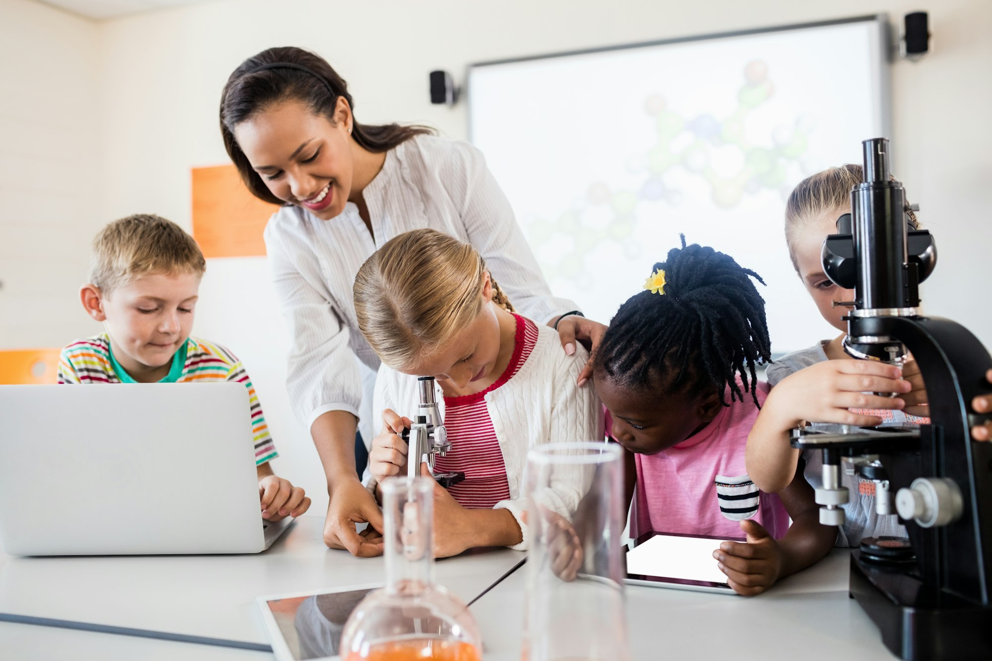 Smiling teacher helping pupils