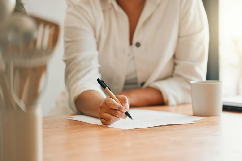 Writing, paperwork and contract with a woman holding a pen and filling out an application form in h